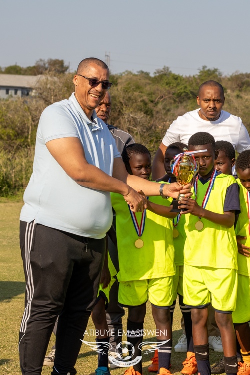 [PHOTO: Lobamba Primary School players Getting their Trophy presented by Phillip Desousa (United Holdings)